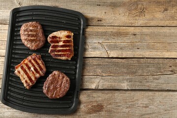 Delicious grilled beef meat on wooden table, top view. Space for text