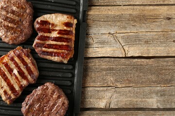 Delicious grilled beef meat on wooden table, top view. Space for text