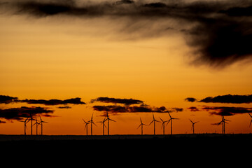 parque eolico  al atardecer generando siluetas 