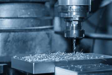 The hole drilling  process on NC milling machine with aluminum parts in the blue scene.