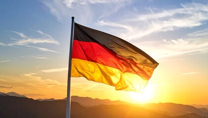 German flag waving at sunset over mountains