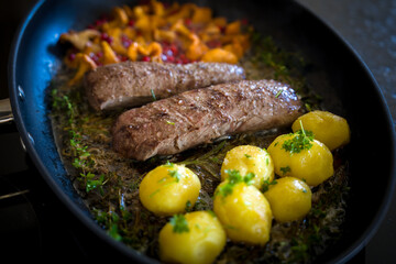 healthy lifestyle - roasted filet from venison, chanterelles with cranberries and potatoes, with fresh herbs out the garden for a delicious meal
