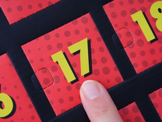 Woman finger pointing at the number 17 on an advent calendar.