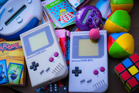 Minneapolis, USA - Sept 16, 2025: A collection of gaming, card, and puzzle items from different decades, with the focus on two original Nintendo Game Boy handheld consoles. For Editorial Use Only.