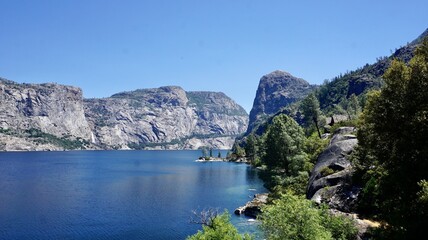 Hetch Hetchy Reservoir with granite cliffs and pine forest in Yosemite National Park, California.