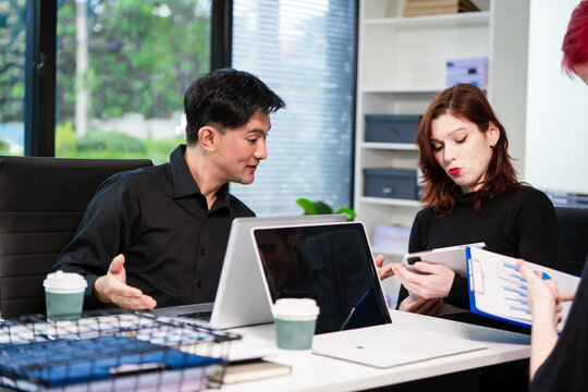 Diverse business team collaborates in modern office, discussing charts, data, strategies. Their professional teamwork reflects communication, leadership, success, productive, innovation cooperation.