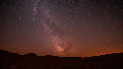 Naklejka premium Vast Milky Way Galaxy Spanning Over Desert Skies