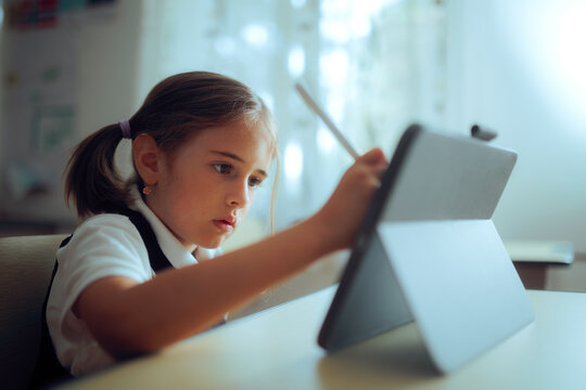 Student Using a Digital Tablet with a Pen During Class. Modern schoolgirl using digital instruments for learning