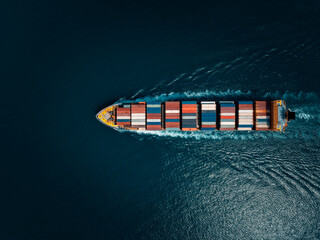 photograph of large container ship sailing on a deep sea, fully loaded with multi-colored...