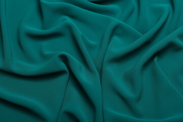 Soft lightweight flowy georgette fabric in teal green, elegantly draped with natural folds. Perfect...