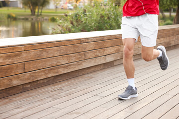 Obraz premium Athletic man in sportswear running outdoors, closeup