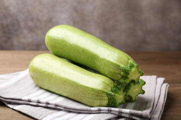Fresh ripe zucchinis on wooden table, closeup