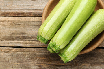 Fresh ripe zucchinis on wooden table, top view. Space for text
