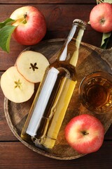 Delicious cider in bottle, glass and apples on wooden table, flat lay