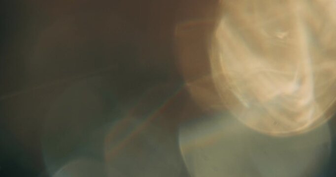 Film Grain Vintage Effect Overlay. Reflection, Refraction and  Bokeh from light through rotating crystal.  Warm Color Balance.