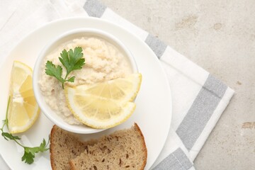 Tasty horseradish sauce with parsley and lemon slices served on light table, top view. Space for text