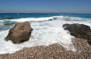 Rocks and surf on Rhodes beach in Greece.
