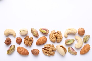 Mix of different nuts on white background, flat lay. Space for text