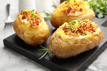 Tasty stuffed baked potatoes on grey table, closeup