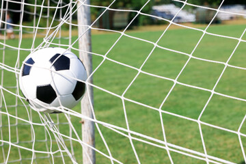 Naklejka premium Hitting soccer ball in net outdoors, closeup. Football game
