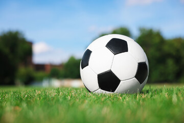 Obraz premium Soccer ball on green grass outdoors, space for text. Football game