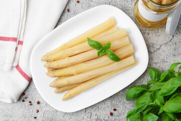 Pickled asparagus, basil and spices on grey table, flat lay
