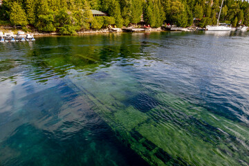 A stunning view of a shipwreck beneath the clear waters of Big Tub Harbour in Tobermory, Ontario, capturing vibrant marine life and nautical history.