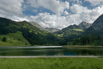 Schwarzsee Lake in the Swiss Alps, Scenic Mountain Landscape with Green Hills and Dramatic Clouds