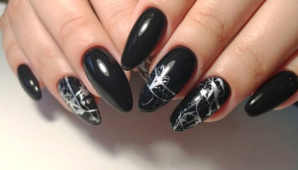 Elegant black nails with intricate silver designs showcase a sophisticated style.