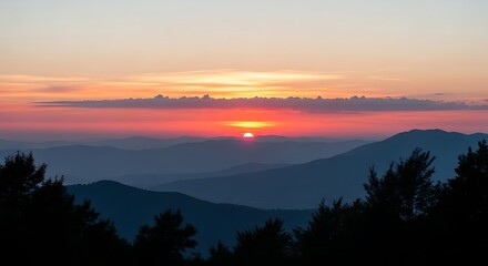 Obraz premium Majestic Sunset Over Layered Blue Mountains and Silhouetted Trees