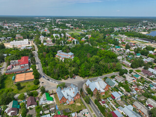 A panoramic aerial view of Gus Khrustalny, showing a mix of red brick residential buildings, a forest, and a busy intersection.
