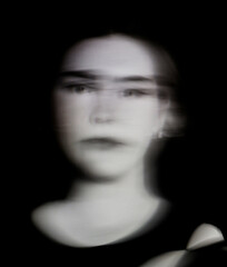 A beautiful young woman closeup with ICM motion blur effect abstract art in monochrome black and white