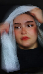 Closeup of a beautiful young woman wearing a veil with ICM motion blur effect abstract art