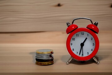 Close-up view of a stack of coins and clock hands . Concept of the idea of time is Money