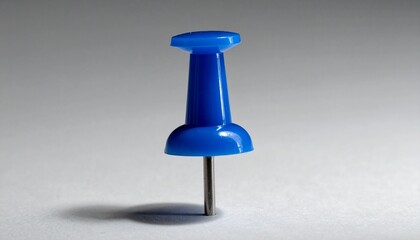 Single blue pushpin on light surface with soft shadow, symbolizing focus and organization.