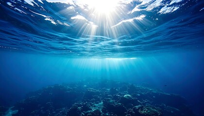 An underwater perspective, showcasing sun rays filtering through the ocean's surface, illuminating a rocky seabed