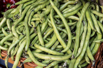 Wide-angle view of a Spanish market stall selling fresh green beans as part of healthy eating and wellness.