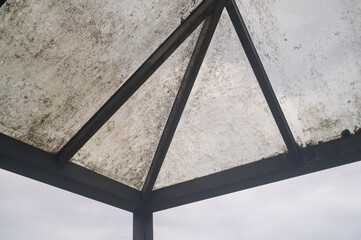 Dirty weathered roof structure against overcast sky