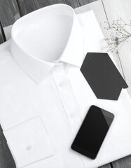 White shirt, phone, tags on wood