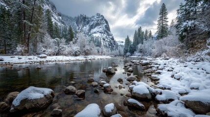 a serene winter landscape in yosemite national park, with a snowy river flowing through a forested area, rocks along the riverbank, and a majestic mountain range in the background under a cloudy sky