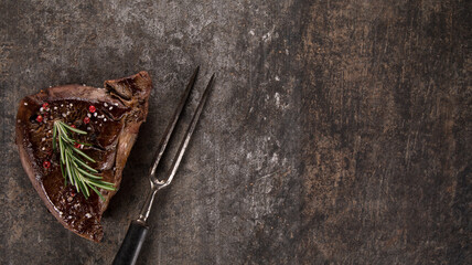 Beef rump steak on black stone table, top down, close-up.