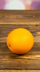 Single orange on wooden surface