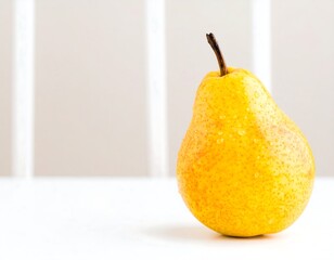 Yellow pear on white surface