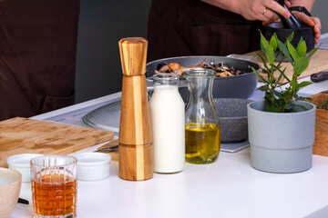 Fresh ingredients displayed on a kitchen counter, including spices, oils, and herbs, showcasing the vibrant cooking preparation process with a focus on culinary artistry