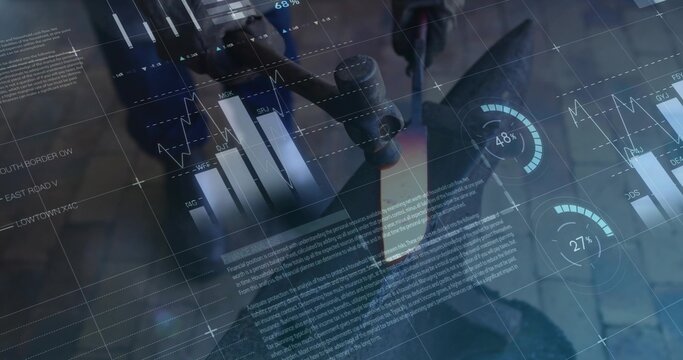 Adjusting scientist in lab coat, gloves turning microscope focus knob at bench with digital charts