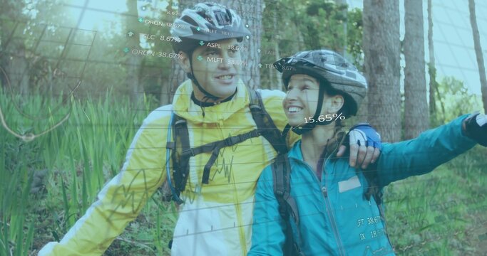 Smiling couple standing on forest path with helmets, backpacks, displaying AR data overlays