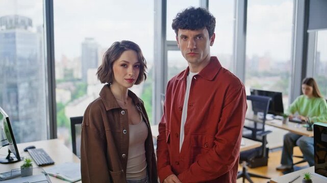 Serious colleagues posing panoramic window coworking looking camera closeup 