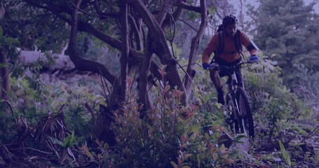 Fototapeta premium Riding mountain biker wearing orange jersey on forest trail with water pack and helmet, copy space