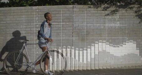 Walking casual woman pushing bicycle by brick wall, overlaid bar chart and line graph, copy space
