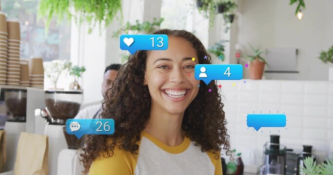Smiling woman wearing baseball tee working at coffee shop counter, with social media graphics - Powered by Adobe